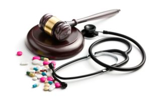 Pharmacy Fraud Cases using gavel and stethoscope with spilled opioid pills